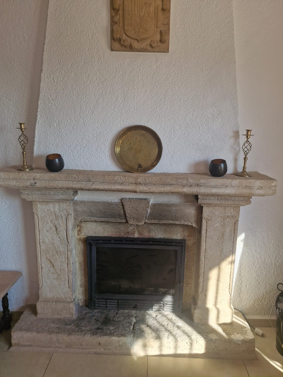 Stone fireplace mantel with brass decor